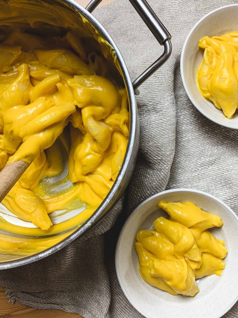 A pot and some bowls of butternut squash pasta.