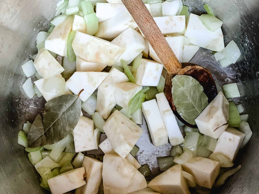 chunks of celery root and onion cooking in a pot.