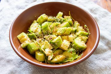 A big bowl of smashed cucumber salad with toasted sesame seeds