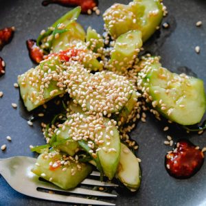 smashed cucumber salad with chiles and sesame seeds on a plate
