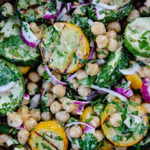 A delicious looking bowl of grilled zucchini and chickpea salad with red onions