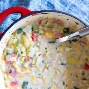 A big pot of hearty corn chowder with a ladle