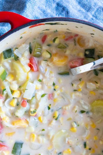 A big pot of hearty corn chowder with a ladle