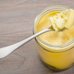 A jar of ghee with a spoon