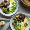 two bowls of polenta topped with poached eggs, roasted mushrooms and fresh dill