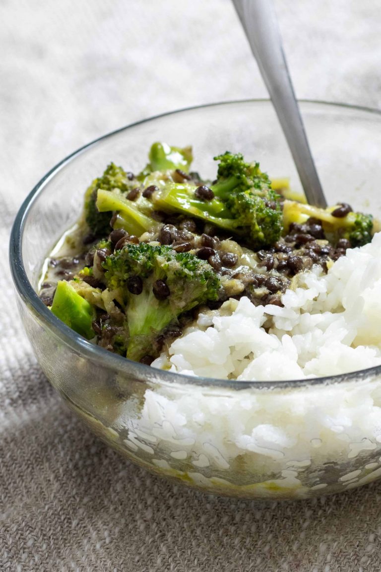 a bowl of black lentil and broccoli curry over steamed jasmine rice.