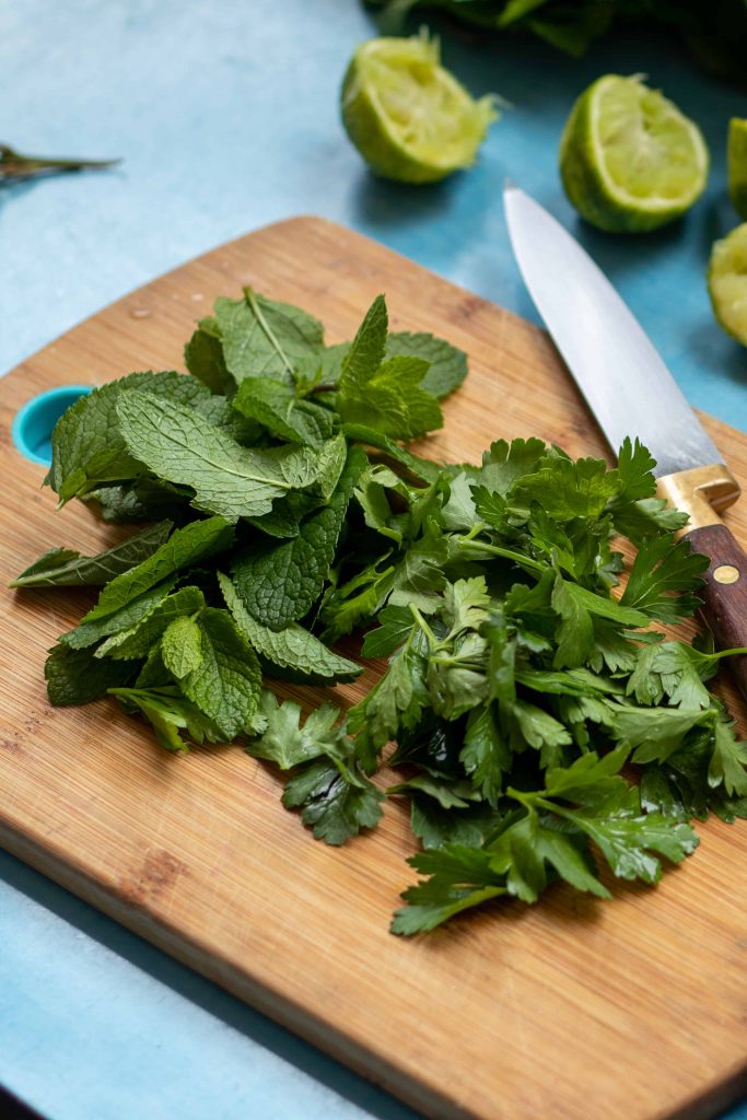 fresh mint and parsley on a cutting board.