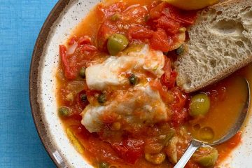 a bowl of summer fish stew on a blue table