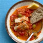 a bowl of summer fish stew on a blue table