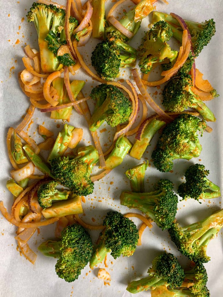 spicy broccoli ready to roast on a tray