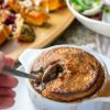 digging into a hearty pot pie with festive salads in the background.