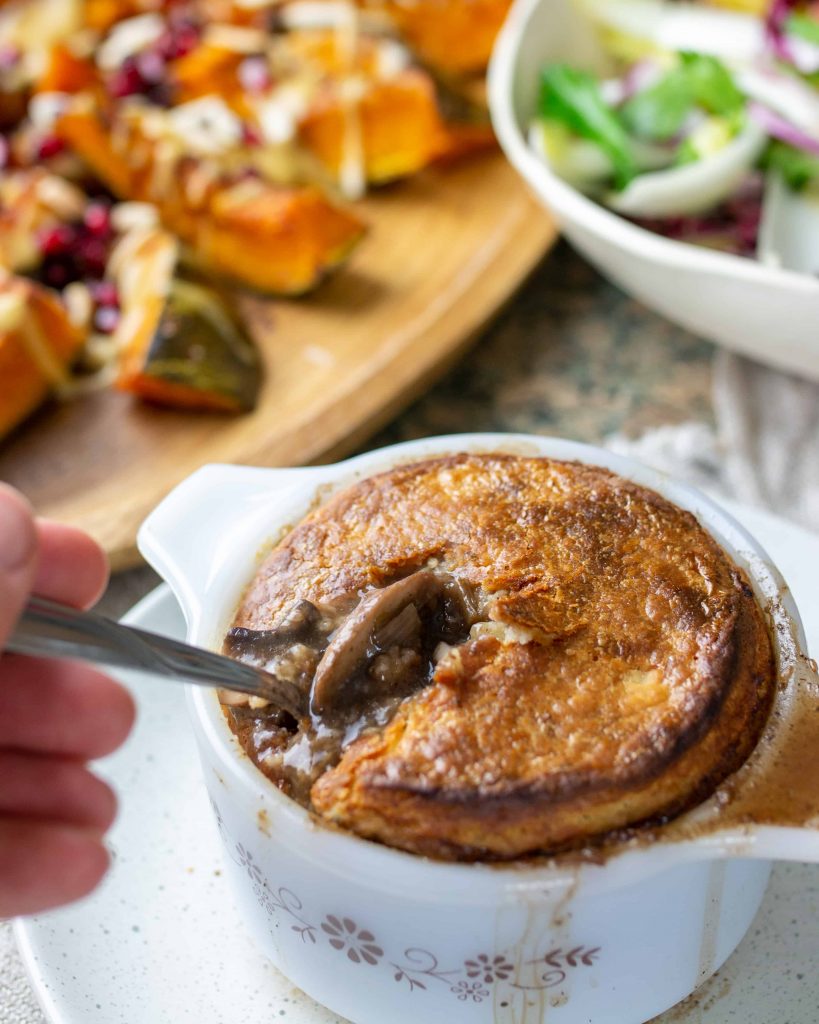 digging into a hearty pot pie with festive salads in the background.