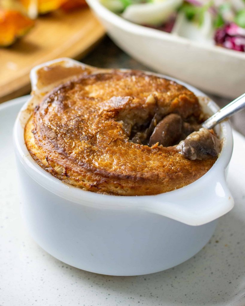 an onion and mushroom pot pie with a spoon in it.