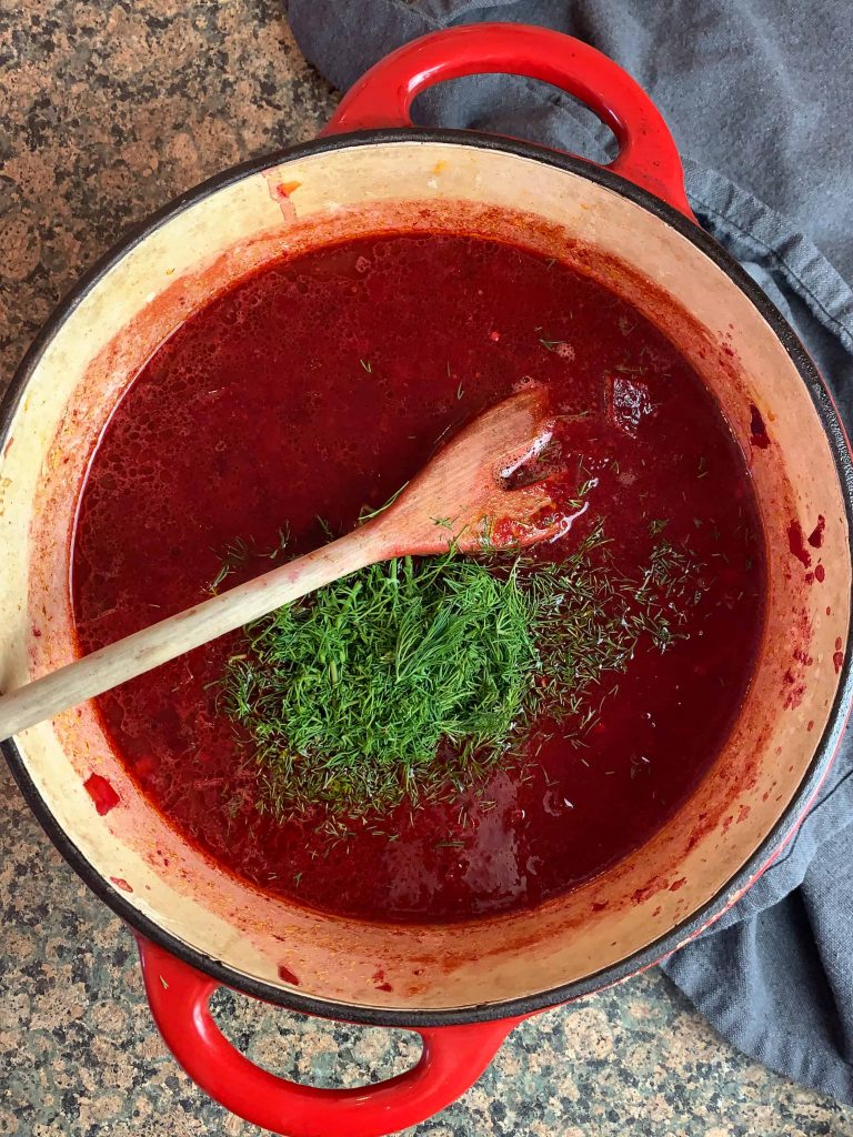 a pot of beet soup with fresh dill.