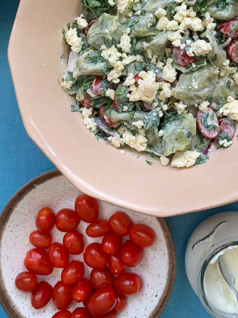 Summer tortellini salad with a bowl of cherry tomatoes on the side.