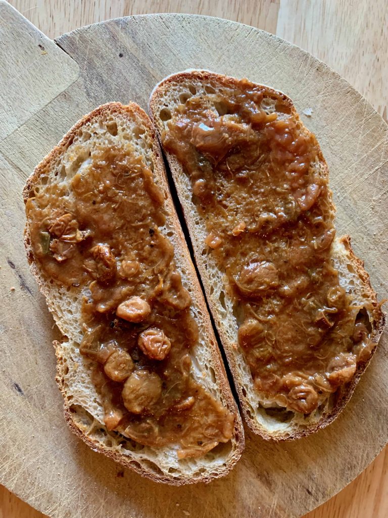 two slices of bread with chutney spread over them.