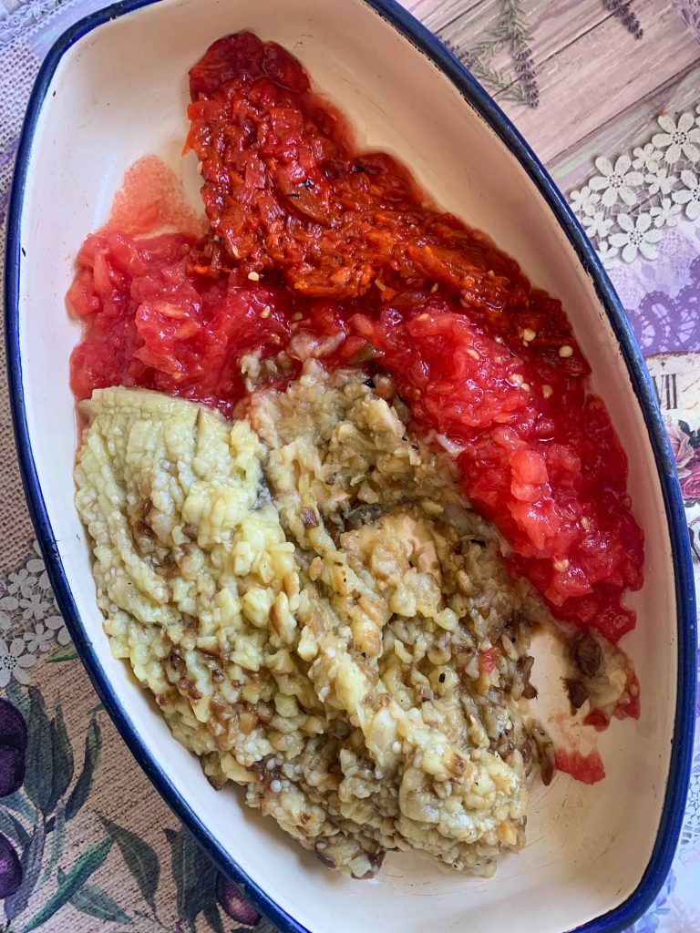 roasted pepper, eggplant, and tomato, chopped finely in a dish.