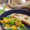 scrambled eggs with fresh herbs and toast on a plate.