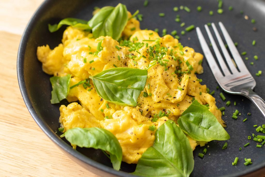 scrambled eggs with fresh herbs on a plate.