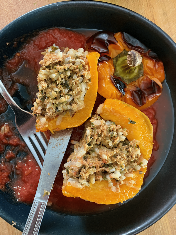 stuffed pepper cut open with tomato sauce.