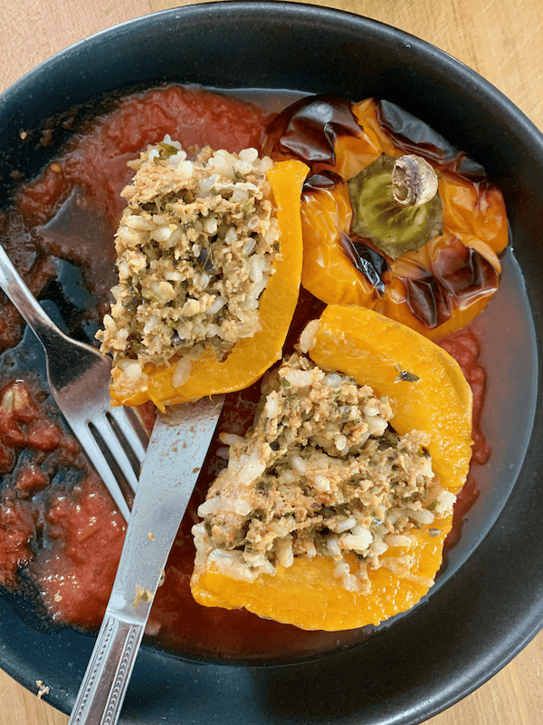 stuffed pepper cut open with tomato sauce.