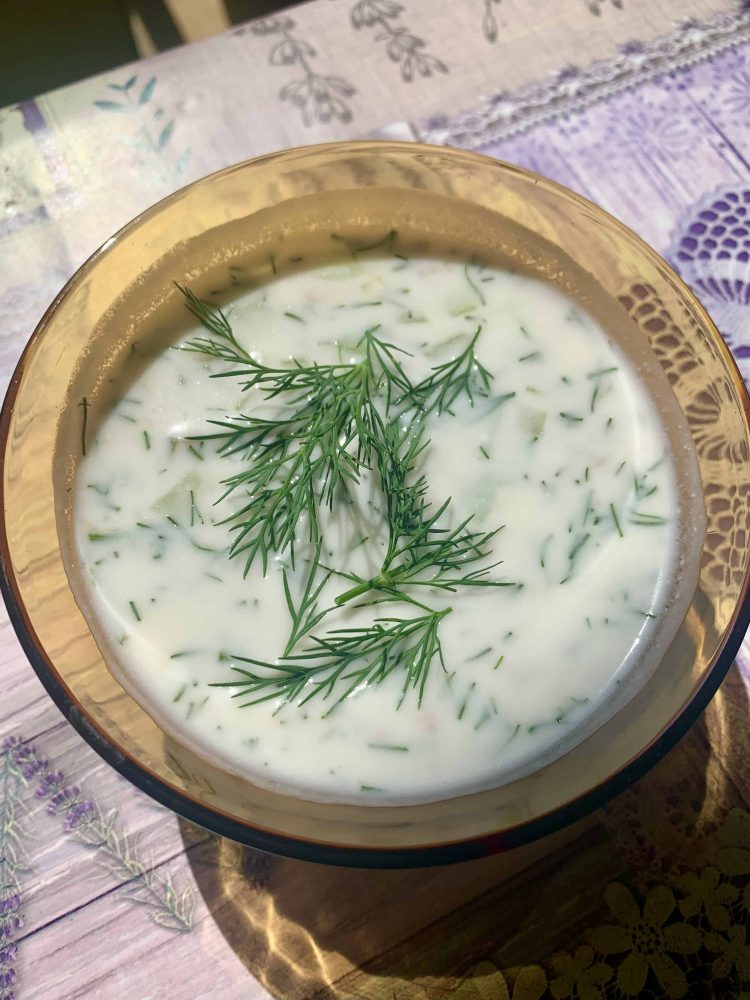 A small bowl of Bulgarian Tarator soup with fresh dill on top.