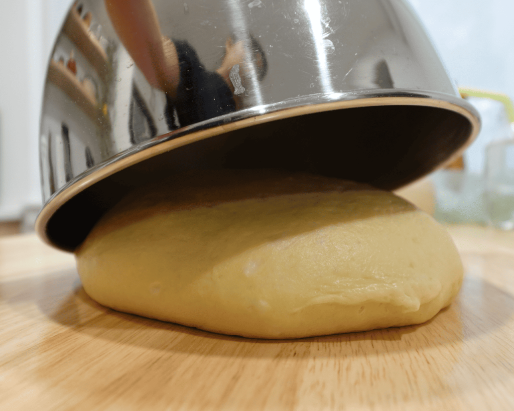 Enriched dough proofing under a bowl.