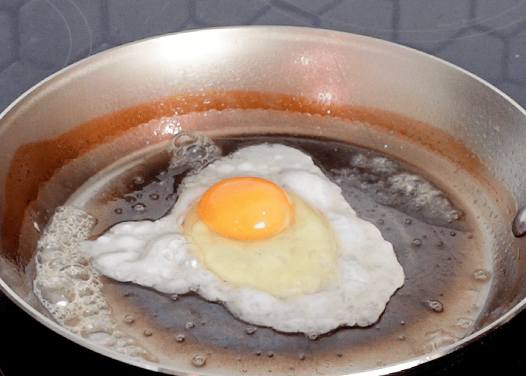 egg frying in carbon steel pan.