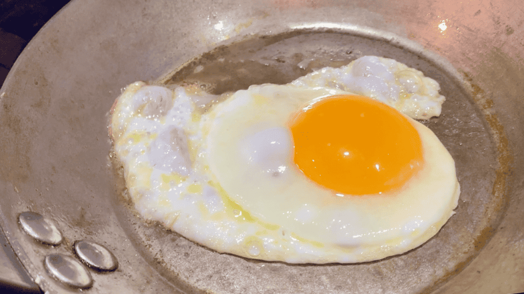 egg frying in carbon steel pan.