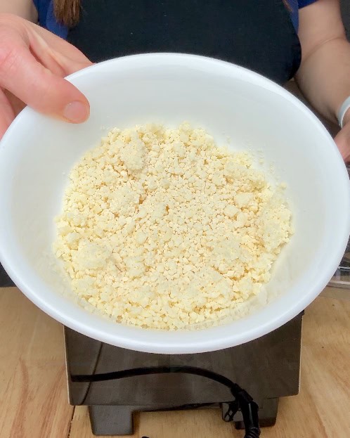 Pre-grated parmesan cheese in a white bowl.