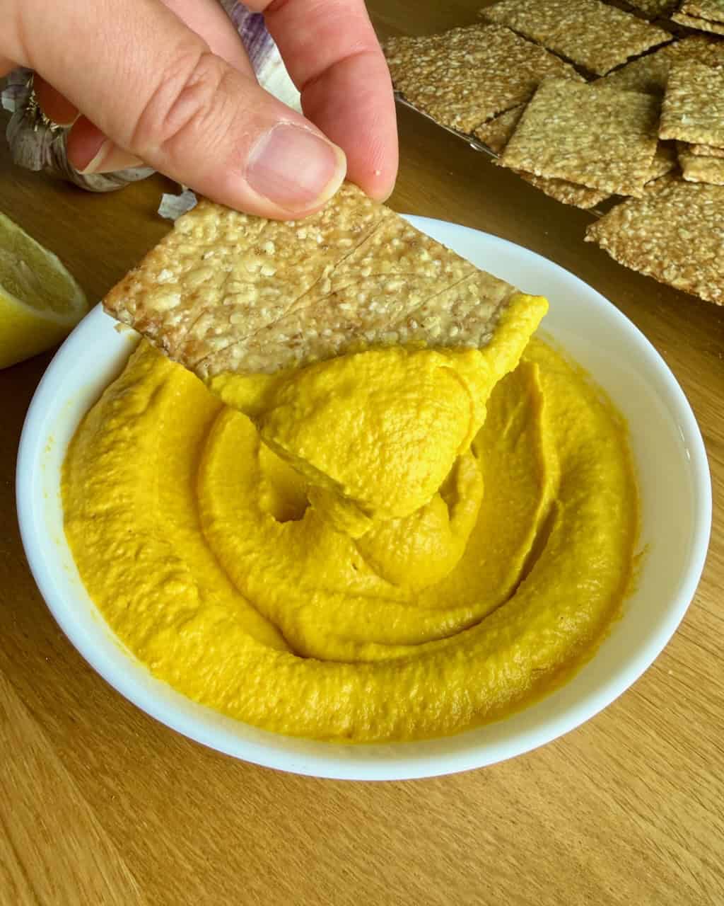 Creamy roasted carrot dip with crispy crackers for a healthy snack.