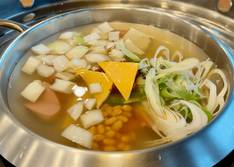 A pot of army stew, ready to be cooked.