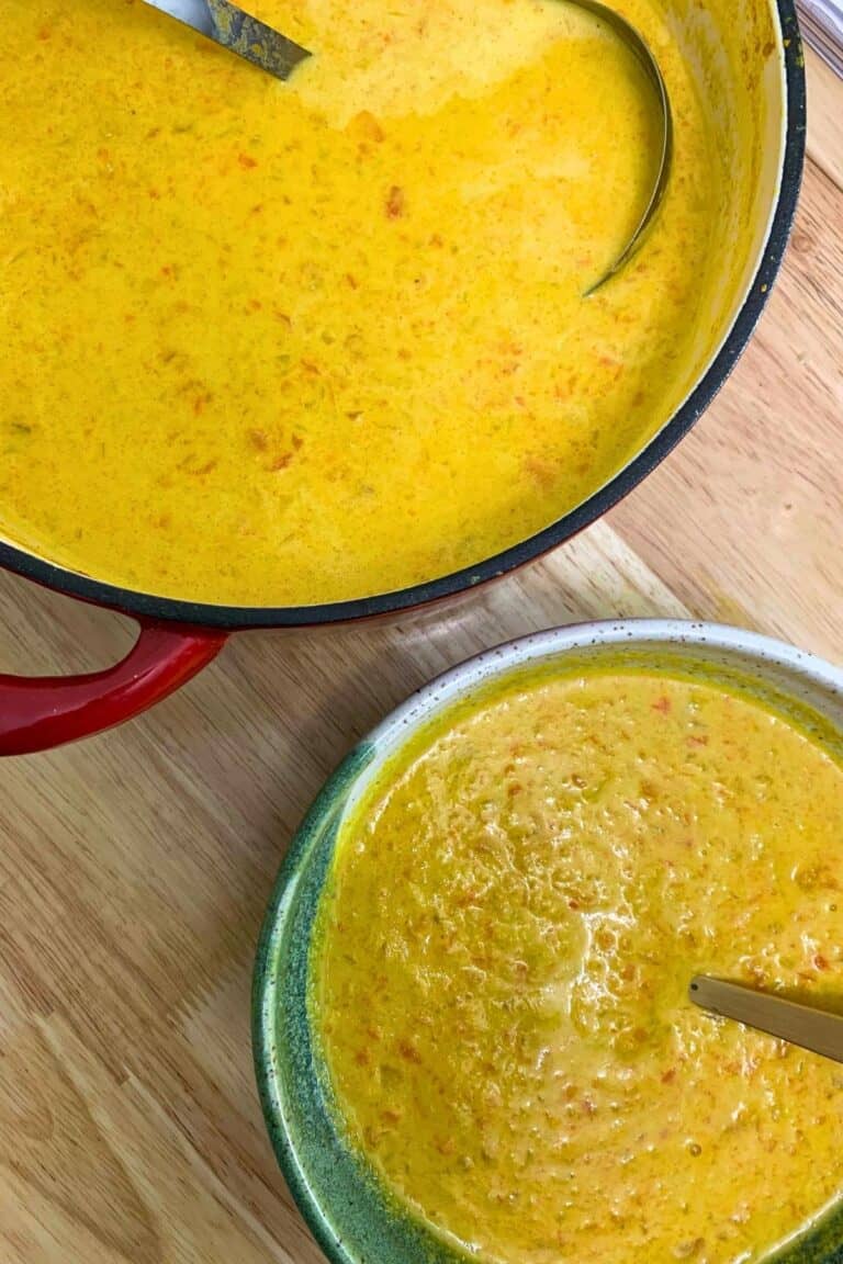 A bowl and a pot of carrot tahini soup.