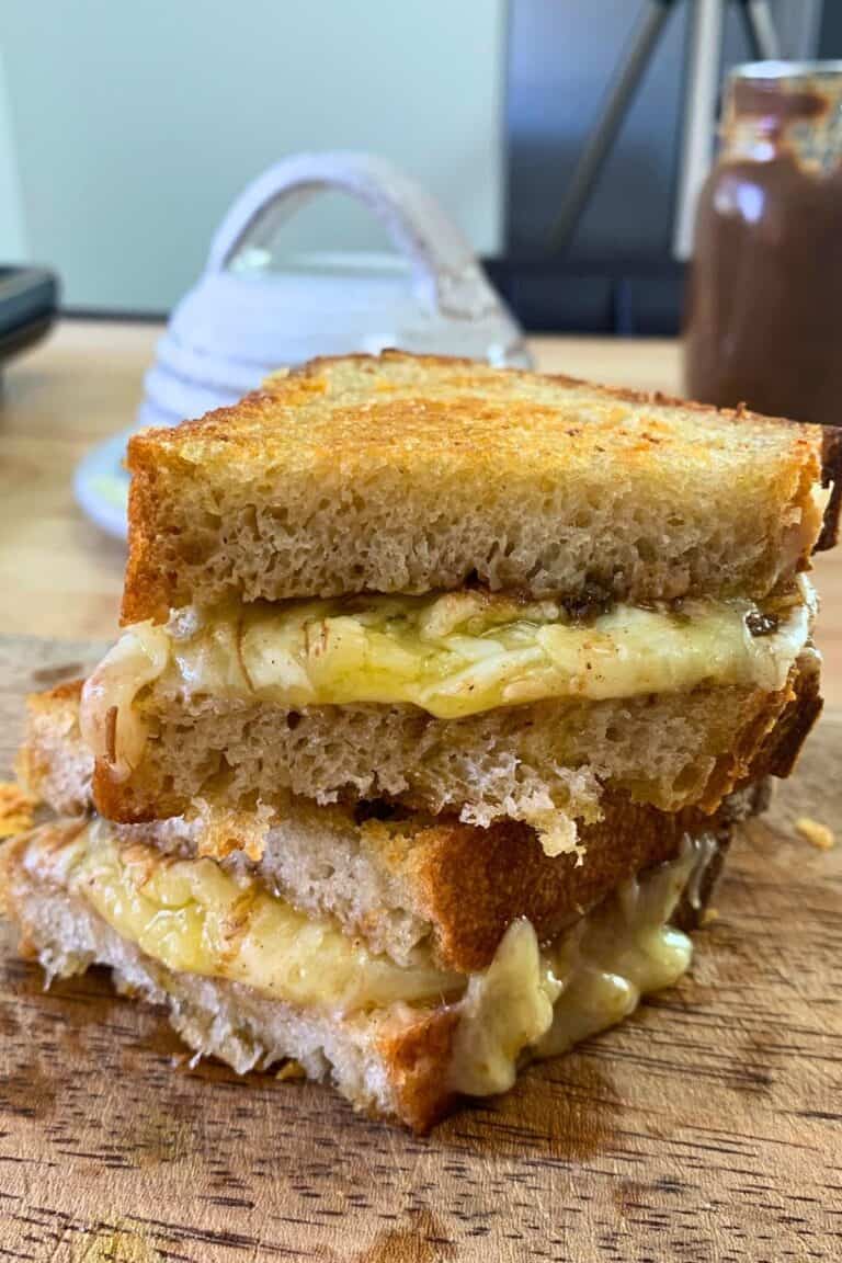 grilled chutney and cheese sandwich on a wooden board.