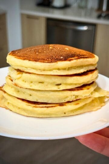 A stack of cottage cheese pancakes on a plate.