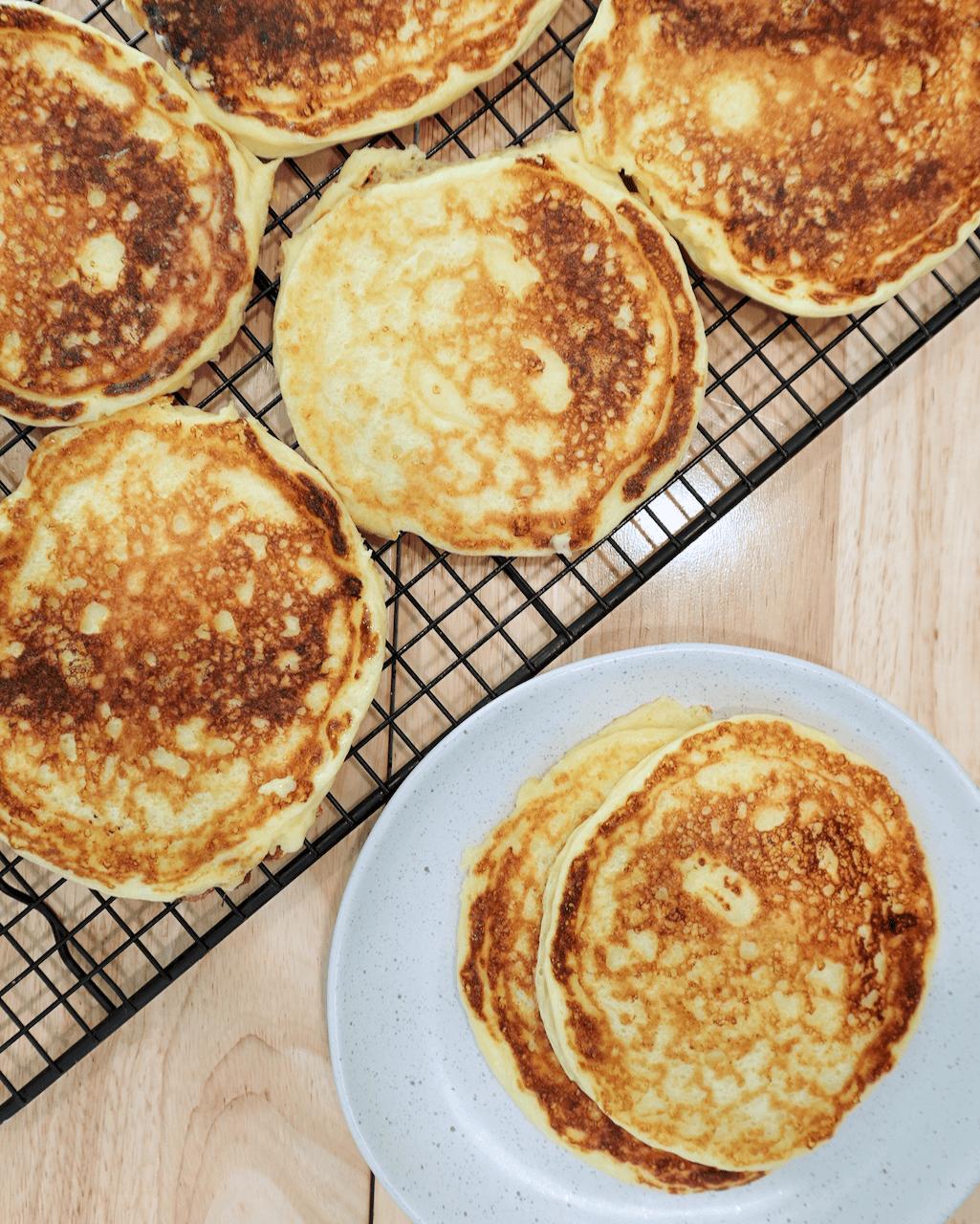 A batch of cottage cheese pancakes cooling on a rack.