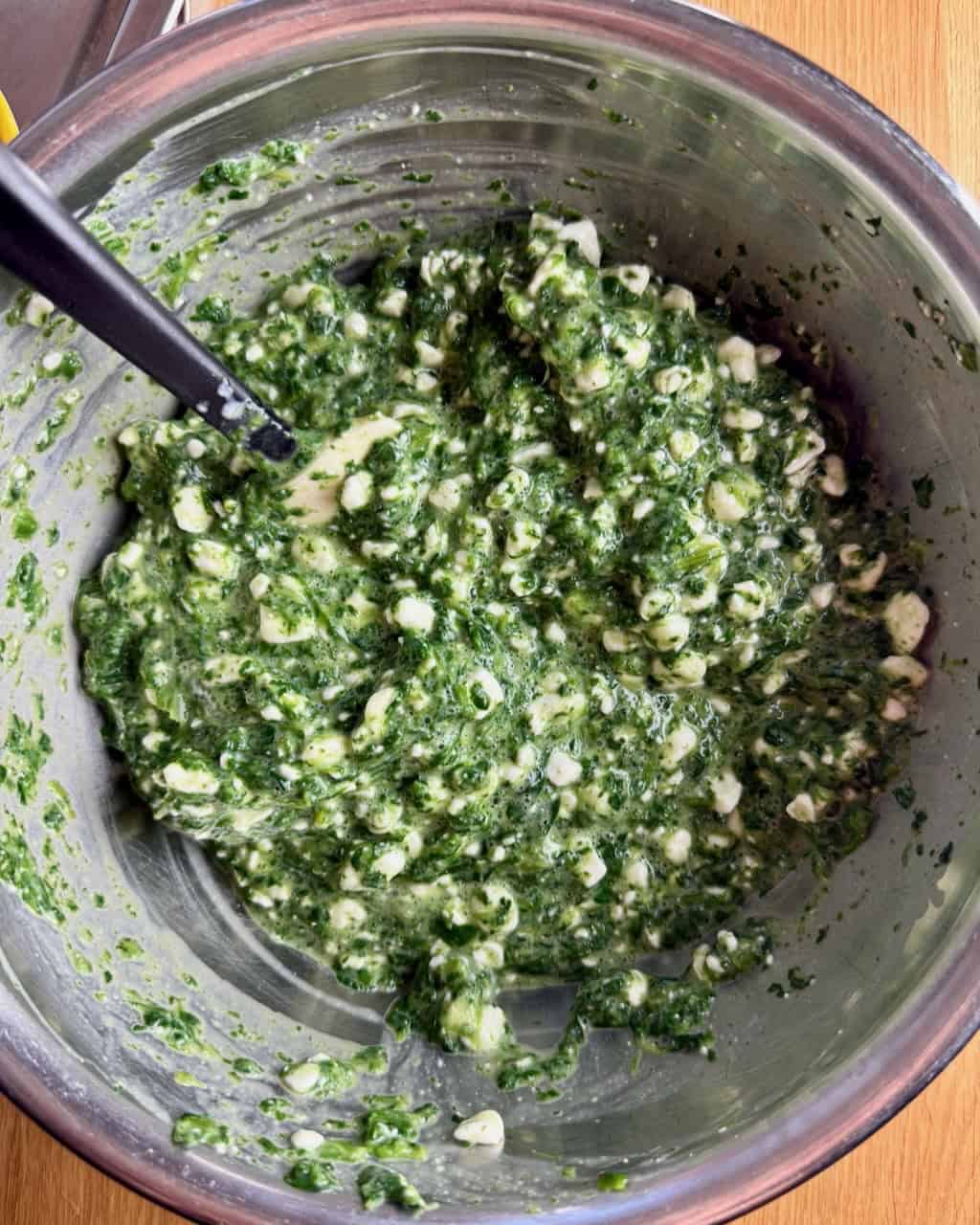 Spinach and cottage cheese mixed together in a bowl.