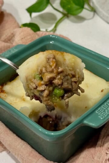 A scoop of turkey shepherd's pie from a single portion dish.