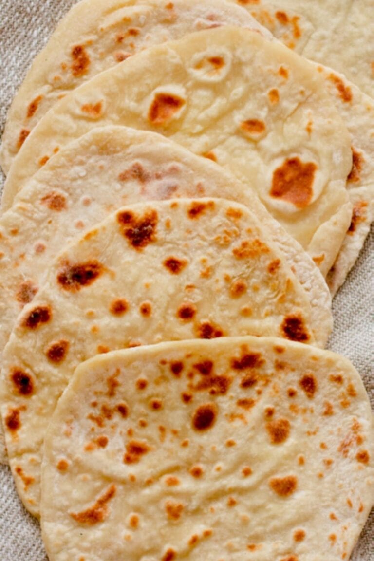 Overhead shot of several flatbreads laid out on a tea towel.