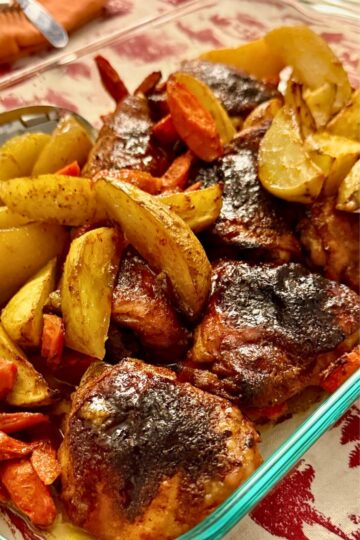 Delicious honey mustard glazed chicken thighs with roasted potatoes and carrots on a sheet pan.