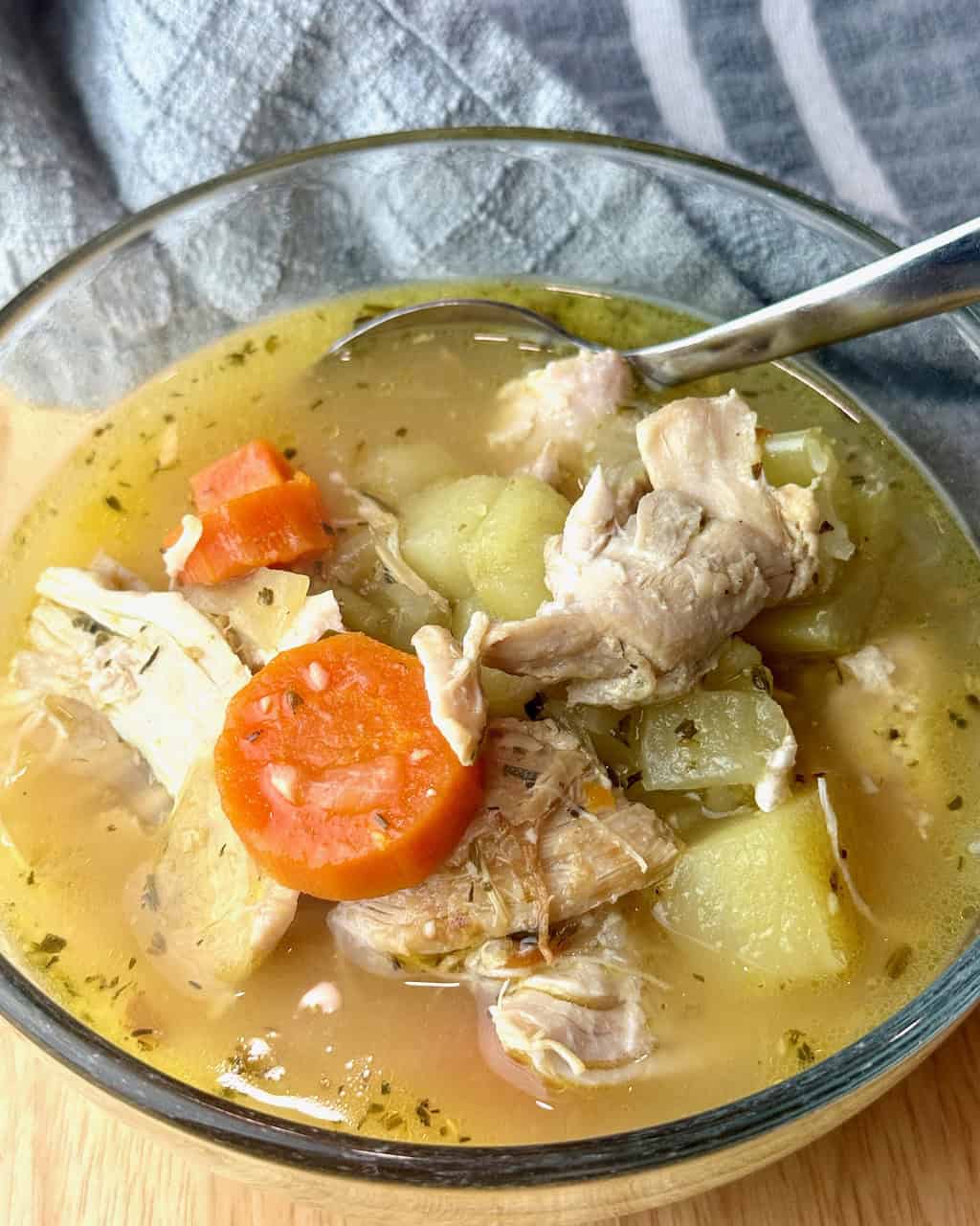 A serving of chicken stew with carrots and potatoes.