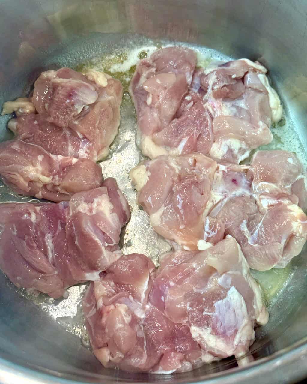 Searing the chicken thighs in butter.