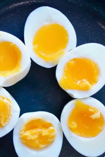 Close up of perfectly cooked jammy eggs on a plate.