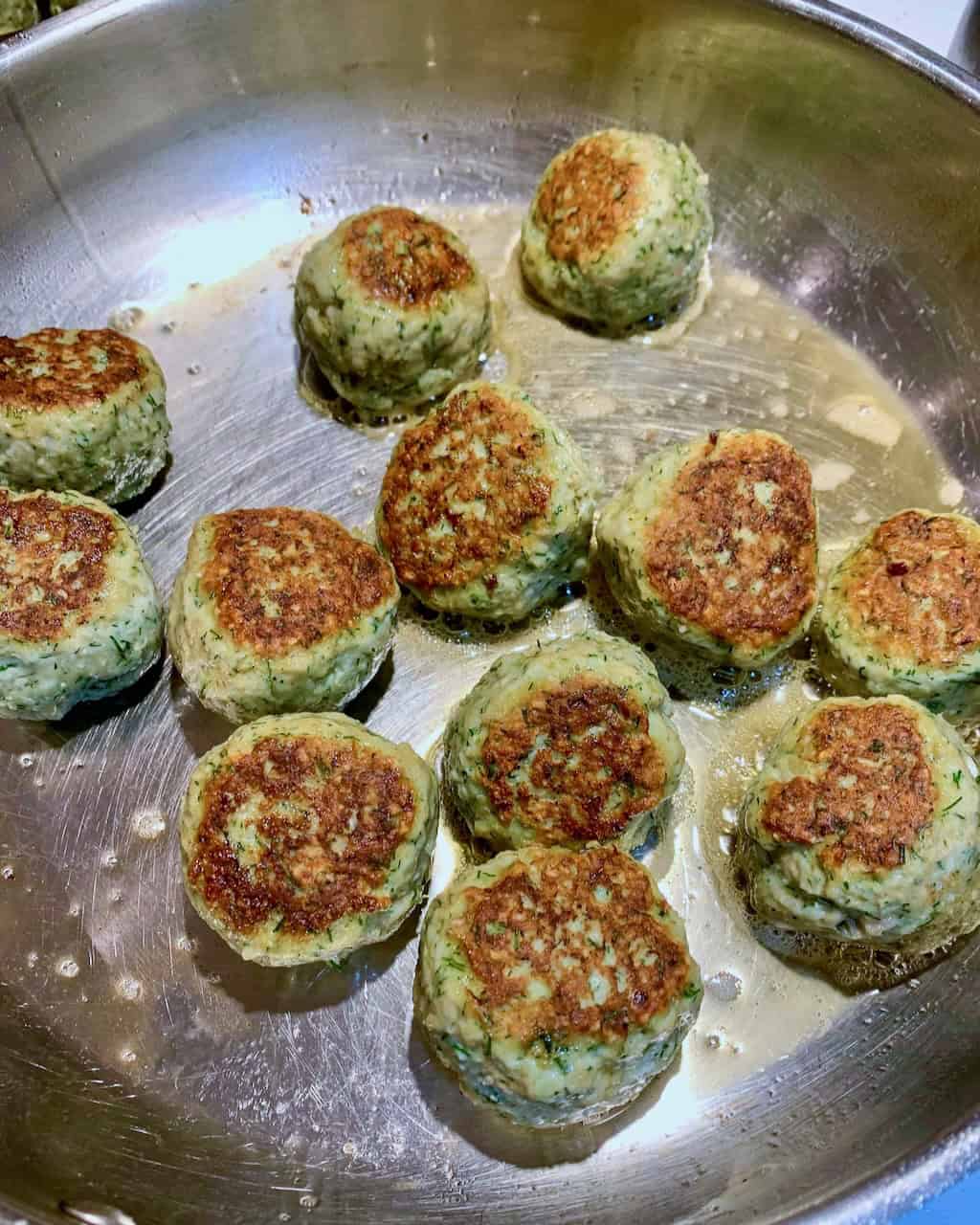 Turkey meatballs frying in a pan.
