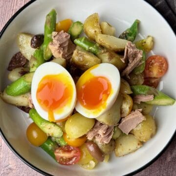 Niçoise potato salad with tuna, fresh vegetables, and a soft-boiled egg.