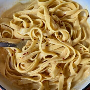 a bowl of fettuccine tossed with creamy nutritional yeast dressing.
