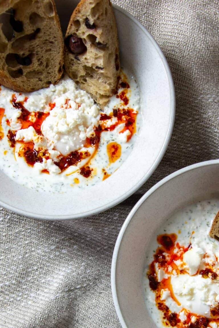Two bowls of Turkish-style eggs with yogurt and chili oil.