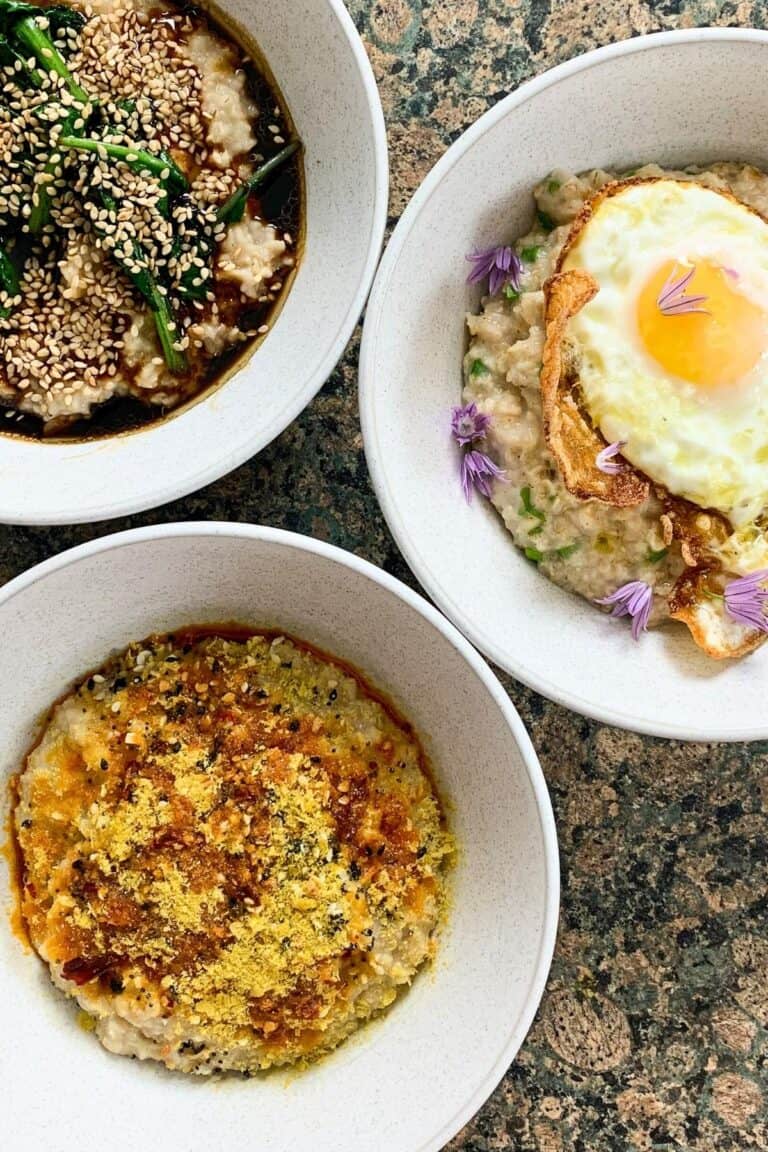 3 bowls of savory porridge topped with eggs, chili oil, greens, and sauces.