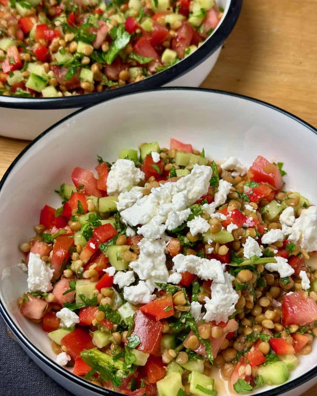 Fresh vegetable and feta cheese salad in a white bowl, ready to serve.