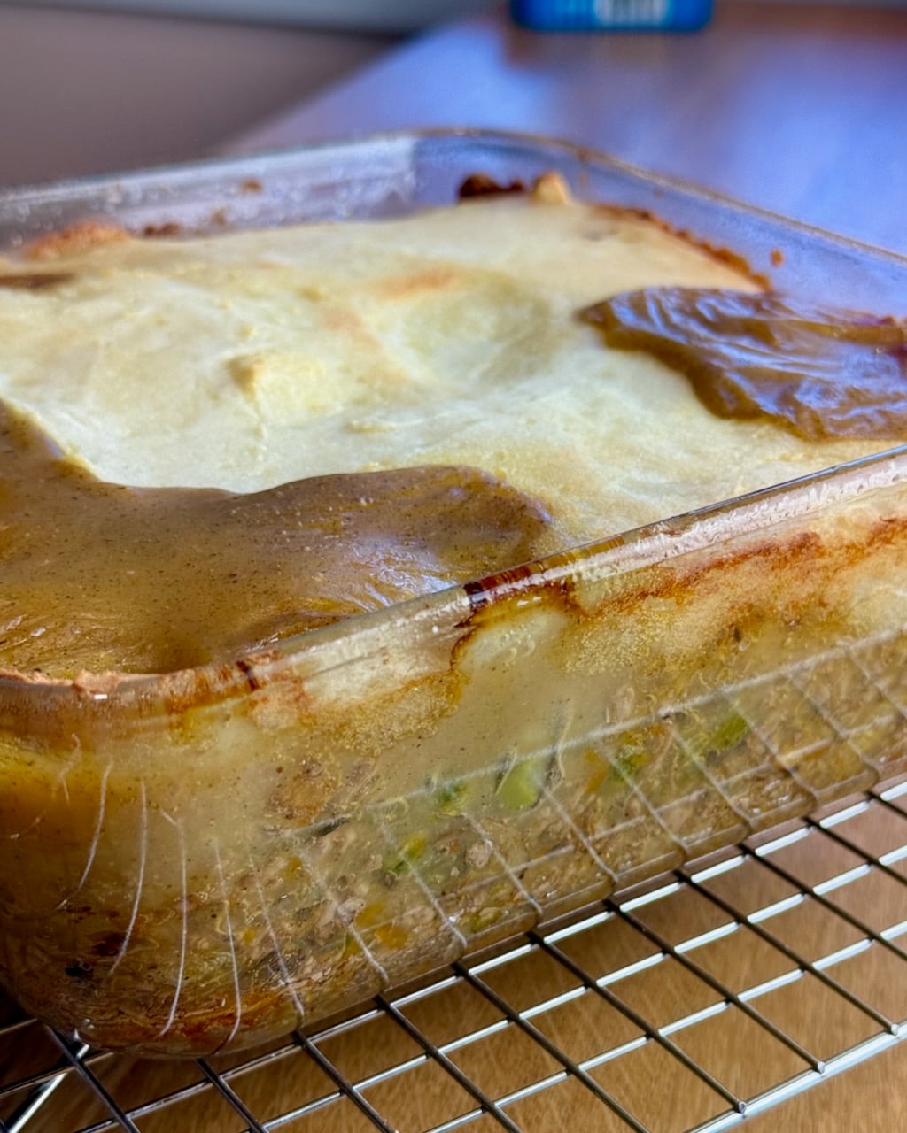 The bubbling pie in a clear dish, cooling on a rack.